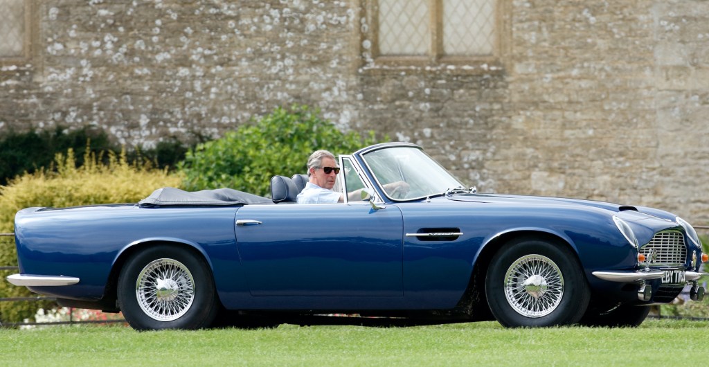 Prince Charles, Prince of Wales accompanied by Camilla, Duchess of Cornwall arrives, driving his 1969 Aston Martin DB6 Volante.