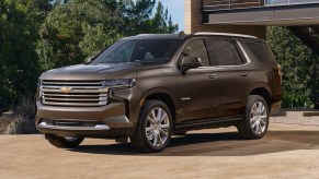 A brown 2021 Chevy Tahoe is parked outside of a house.