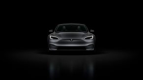 A black Tesla Model S Plaid in a black room