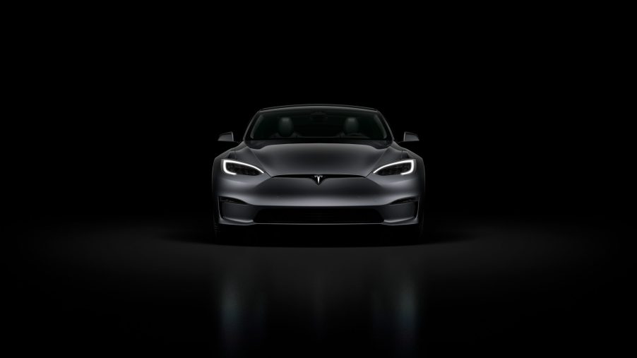 A black Tesla Model S Plaid in a black room