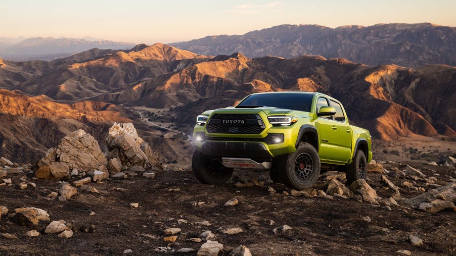 The 2022 Toyota Tacoma TRD Pro in Electric Lime climbing over rocks