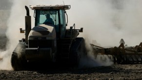 A tractor kicks up dust as it plows a dry field on May 26, 2021, in Chowchilla, California