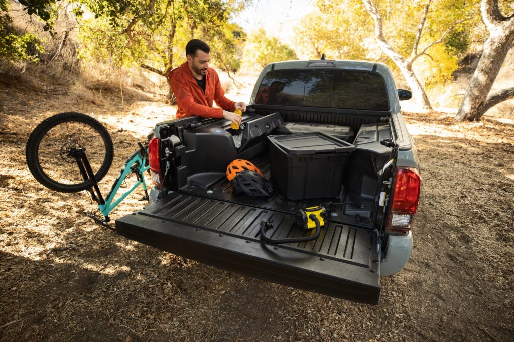 Bed view of the 2022 Toyota Tacoma Trail Edition off-road pickup truck at a campsite loaded with gear. 