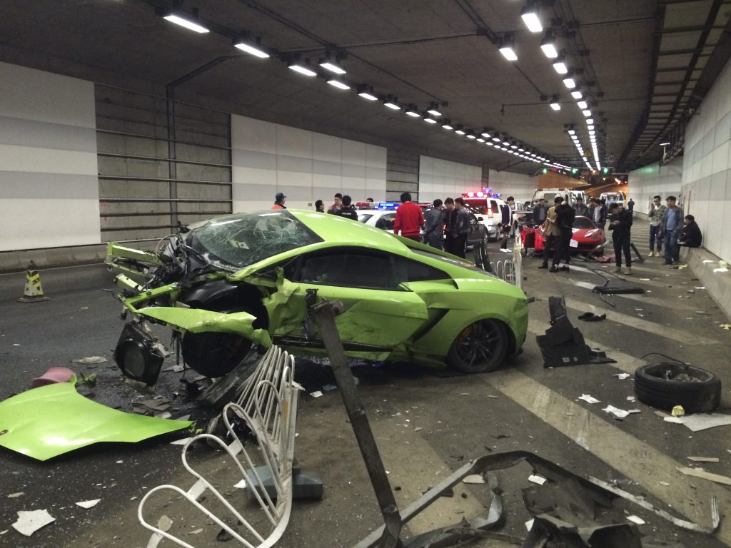 A wrecked exotic car lamborghini after crashing into a ferrari