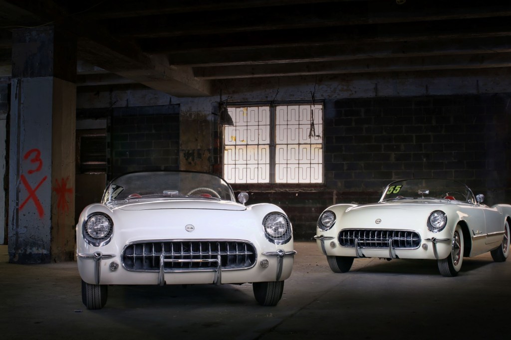 The white Lost 1954 Chevrolet Corvette next to the white Lost 1955 Chevrolet Corvette in a garage