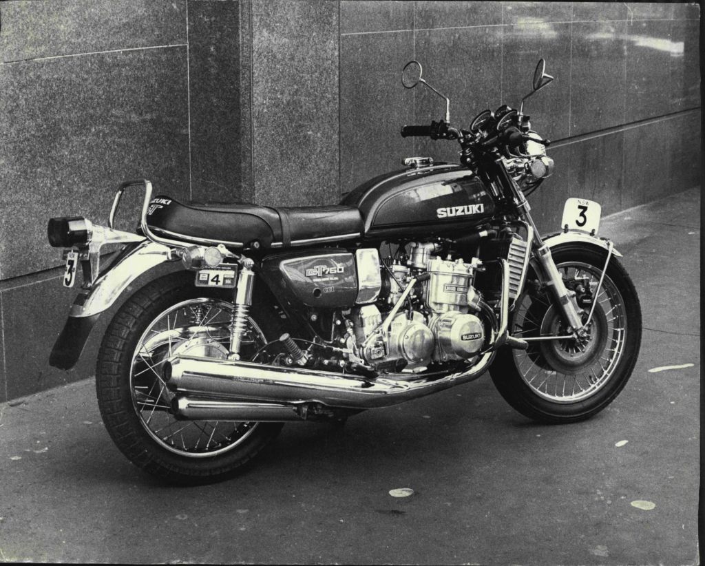 A black-and-white photo of a 1974 Suzuki GT750 in the city