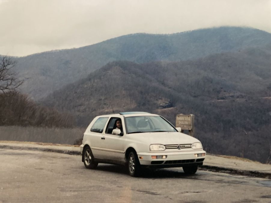 A 1995 Volkswagen Golf GTI model parked near grassy hills