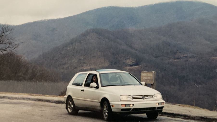 A 1995 Volkswagen Golf GTI model parked near grassy hills