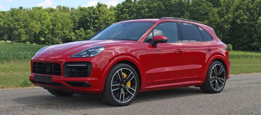 A red 2021 Porsche cayenne with trees in the background.