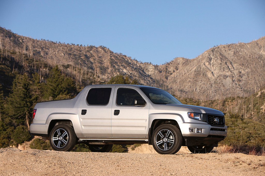 A silver 2012 Honda Ridgeline Sport in the wilderness, the Ridgeline is one of the most affordable used compact trucks