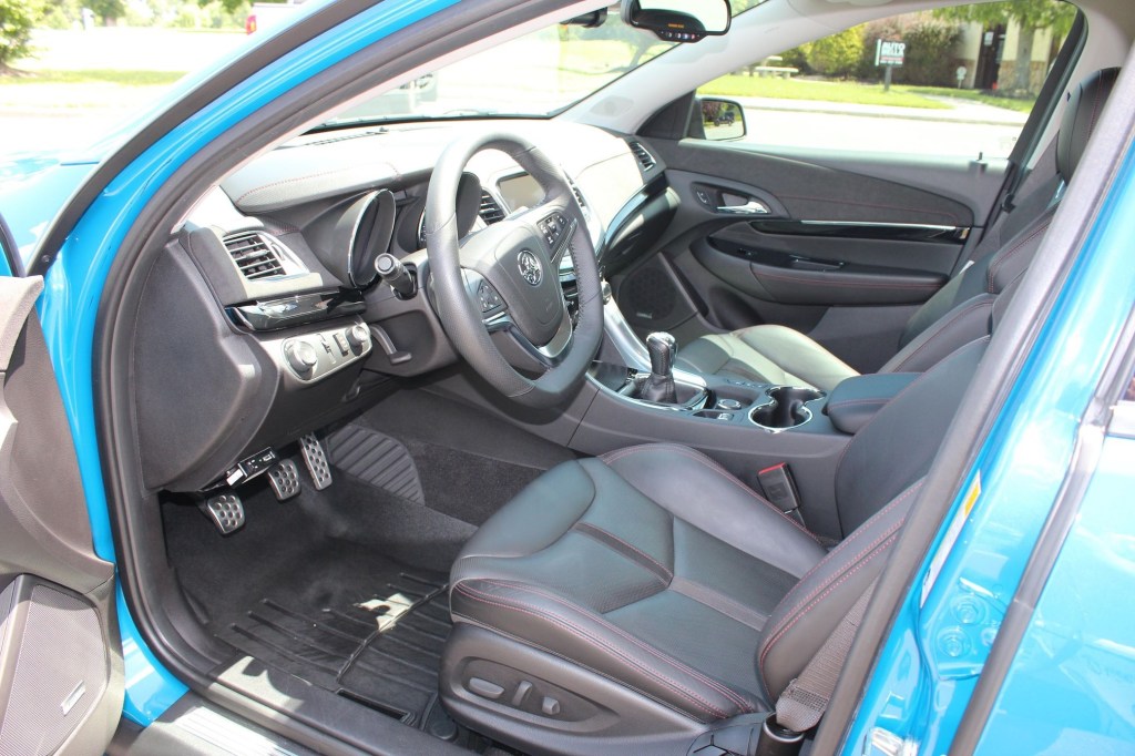 The red-stitched-black-leather-upholstered front sport seats and dashboard of a blue Holden-badged 2015 Chevrolet SS