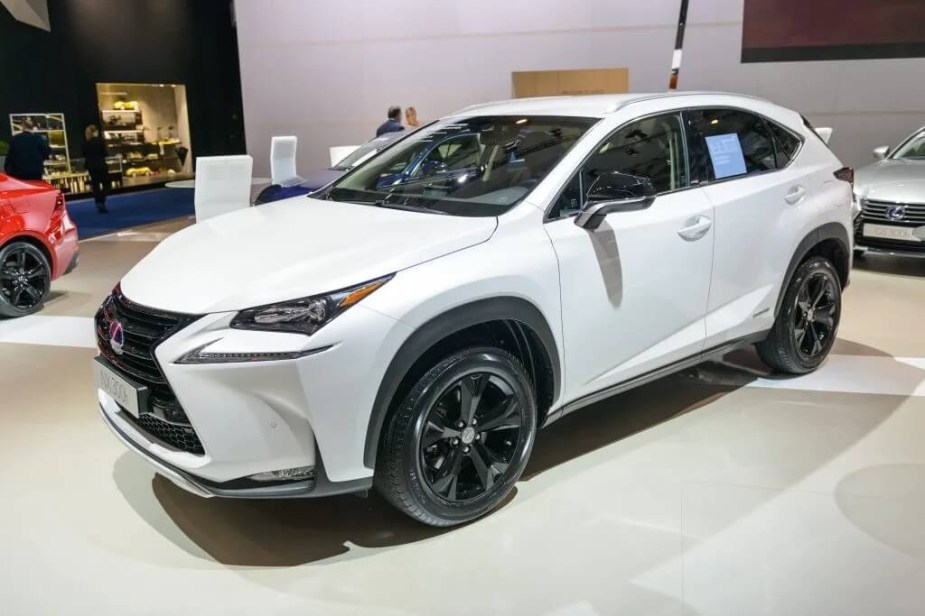 a white 2016 Lexus NX hybrid on display at an indoor auto show is an example of one of the best used lexus SUVs 