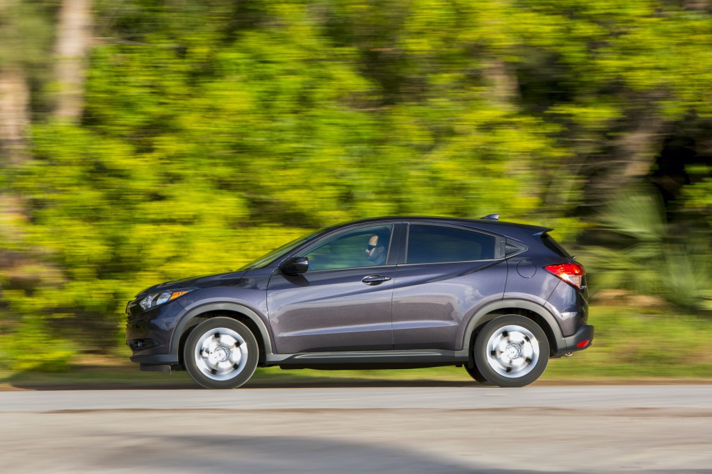a 2017 Honda HR-V driving on a scenic wooded road 