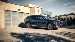 A dark grey 2018 Mazda CX-9 parked in a driveway, the 2018 Mazda CX-9 is one of the best CPO three-row SUVs under $30,000