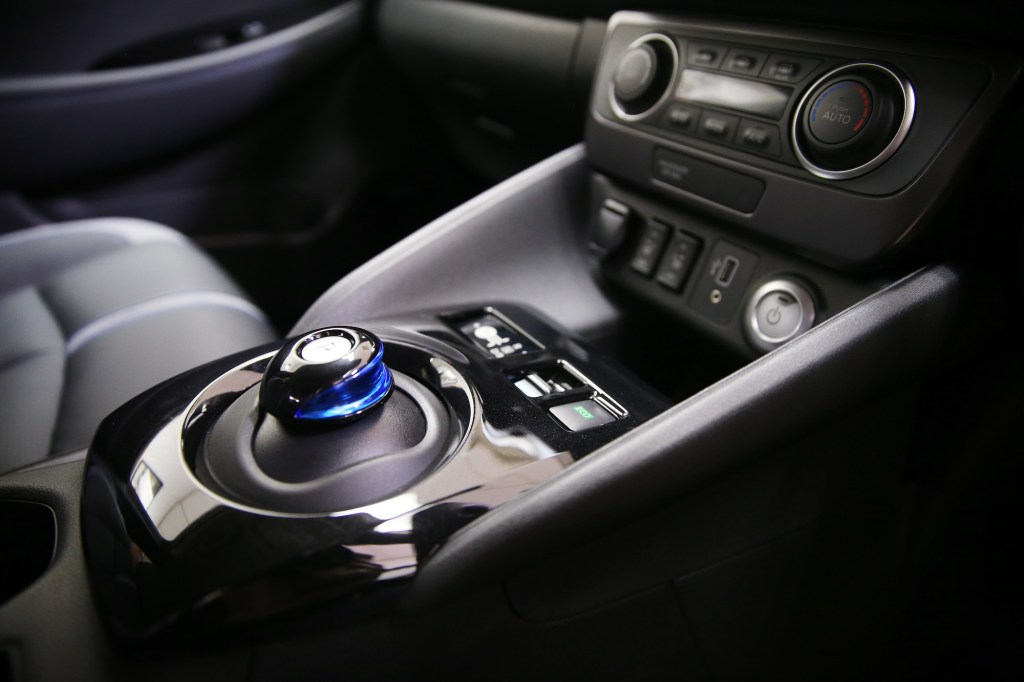 A 2019 Nissan Leaf's center console showing a gear shifter and other controls. The Leaf is vegan-friendly.