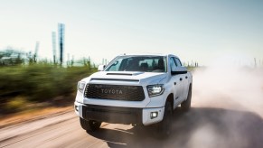 A white 2019 Toyota Tundra driving down a dirt road with dust surrounding it, the 2019 Toyota Tundra is one of the most reliable used Toyota Tundra model years