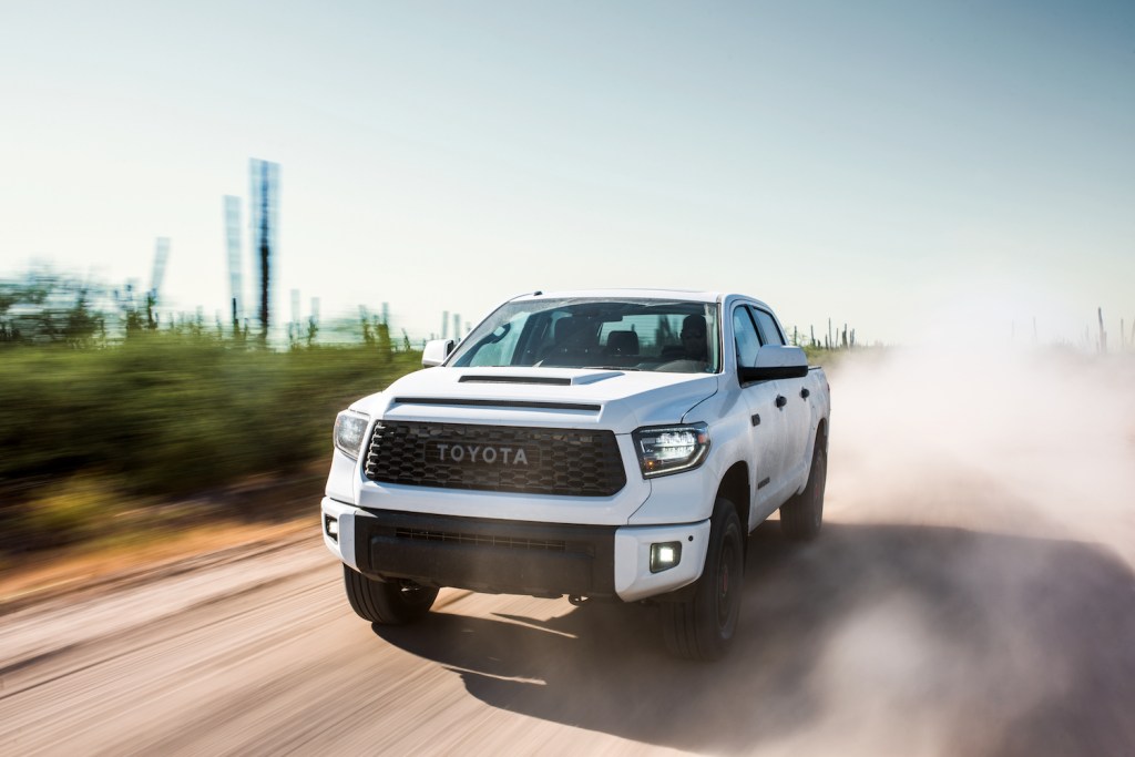 A white 2019 Toyota Tundra driving down a dirt road with dust surrounding it, the 2019 Toyota Tundra is one of the most reliable used Toyota Tundra model years