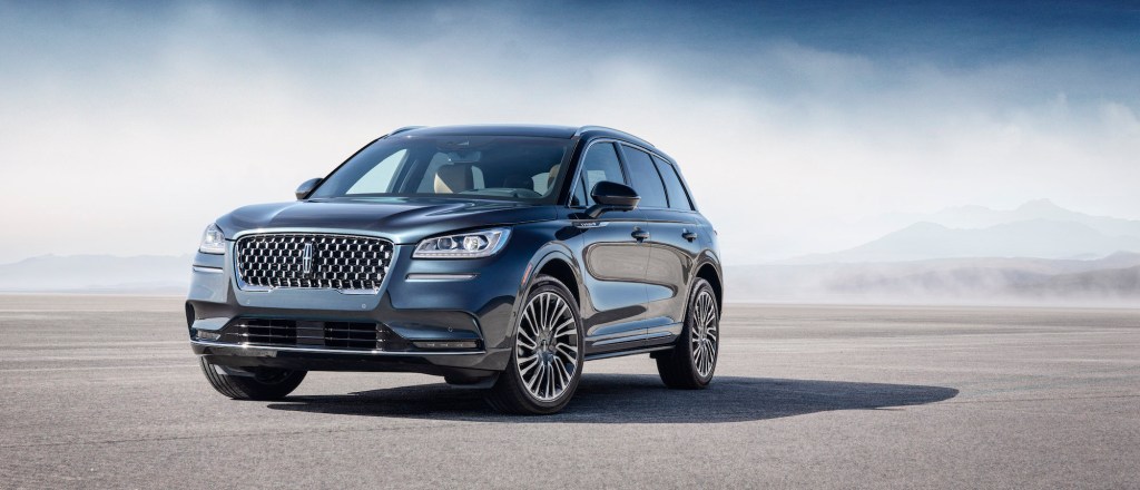 A bluish-gray 2020 Lincoln Corsair luxury compact SUV parked on asphalt in front of mist and mountains