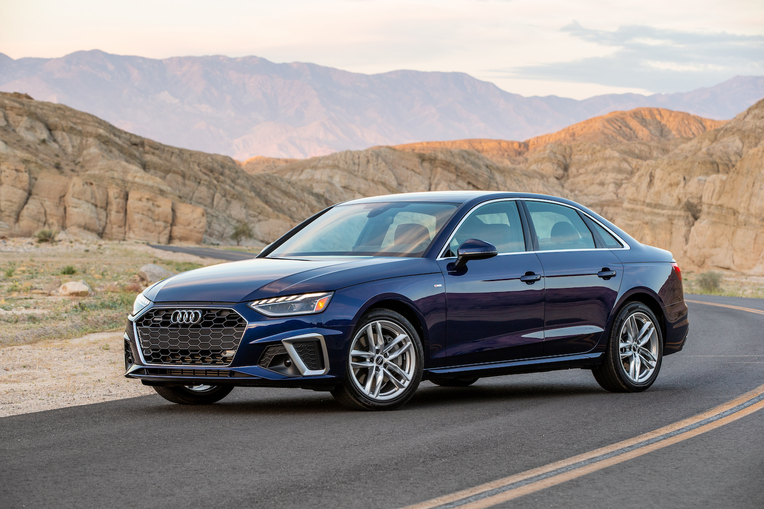 A 2021 Audi A4 parked on the side of the road with mountains and desert behind it, the 2021 Audi A4 is an AWD sedan