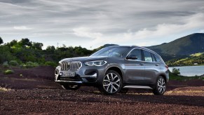 A grey 2021 BMW X1 driving up a hill, the 2021 BMW X1 is the cheapest new BMW SUV