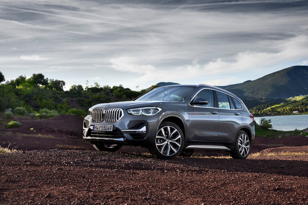 A grey 2021 BMW X1 driving up a hill, the 2021 BMW X1 is the cheapest new BMW SUV