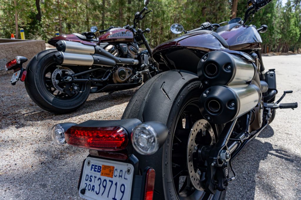 The rear 3/4 view of two maroon 2021 Harley-Davidson Sportster S bikes on the Angeles Crest Highway