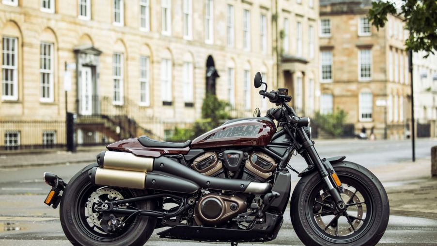 The side view of a maroon-and-black 2021 Harley-Davidson Sportster S in a European city