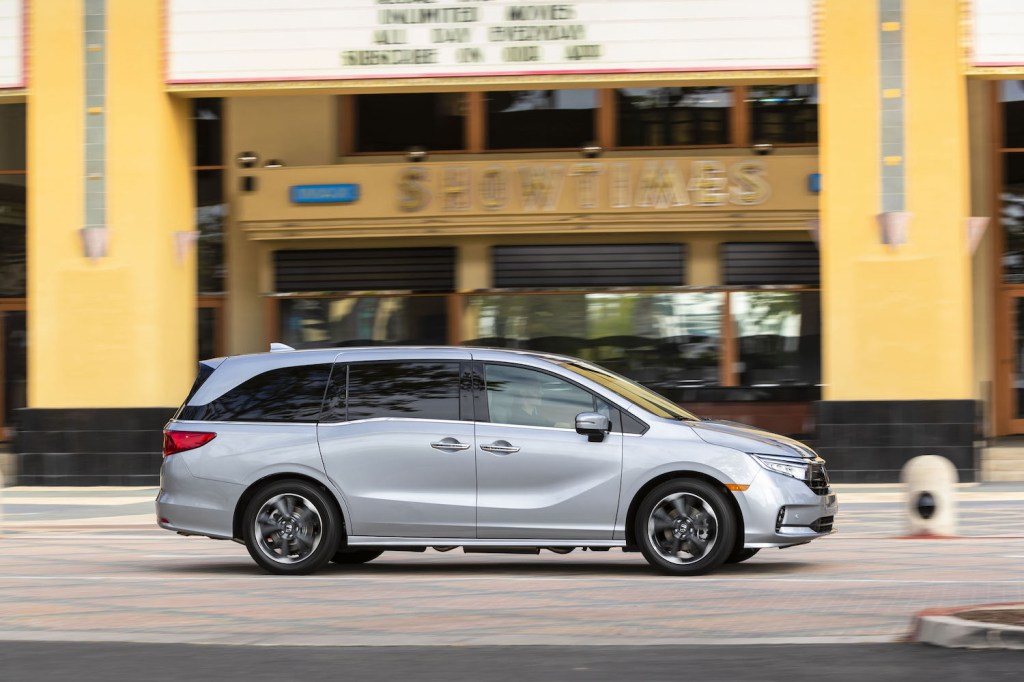 A silver 2021 Honda Odyssey driving, the 2021 Honda Odyssey is a cheaper alternative to the Chrysler Pacifica, a new car being sold over list price