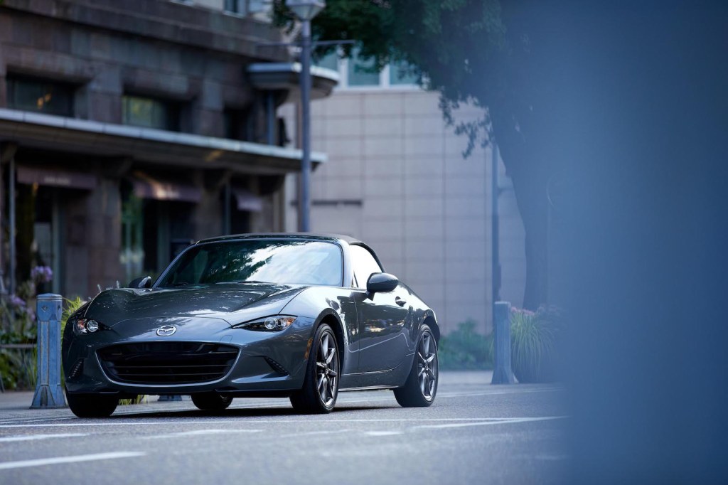 A 2021 Mazda MX-5 Miata  parked downtown, the Miata is an affordable new sporty car