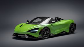 A green-and-black 2021 McLaren 765LT Spider with its roof down