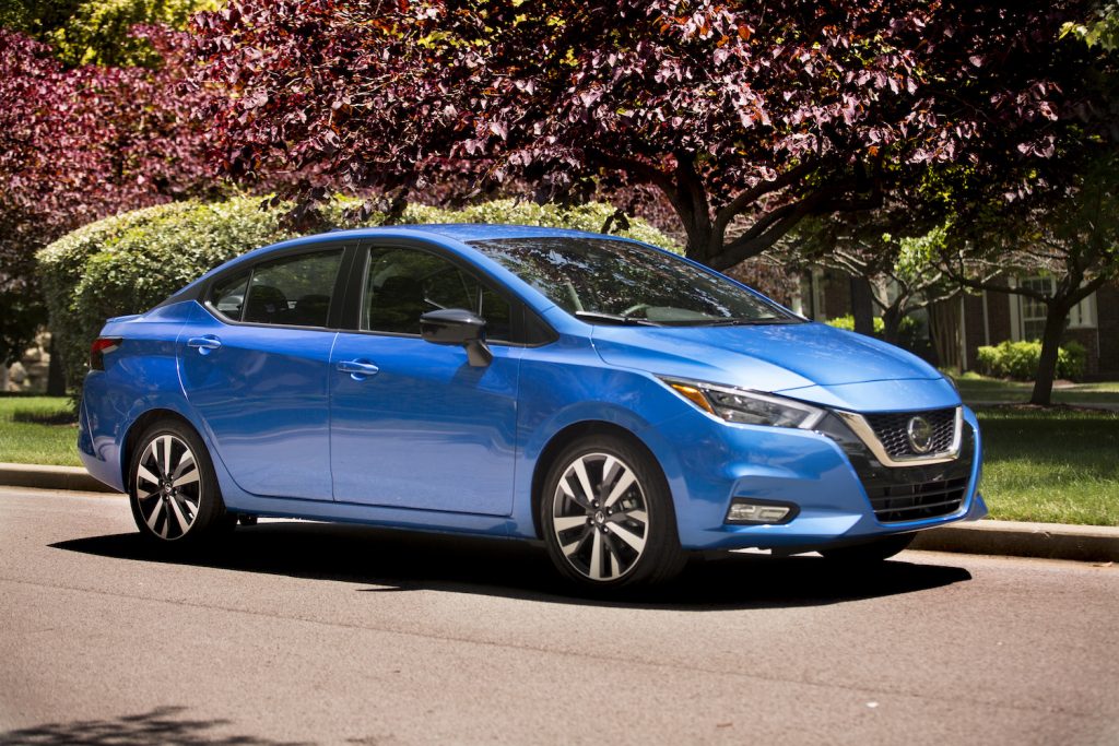 A blue 2021 Nissan Versa parked by flowers
