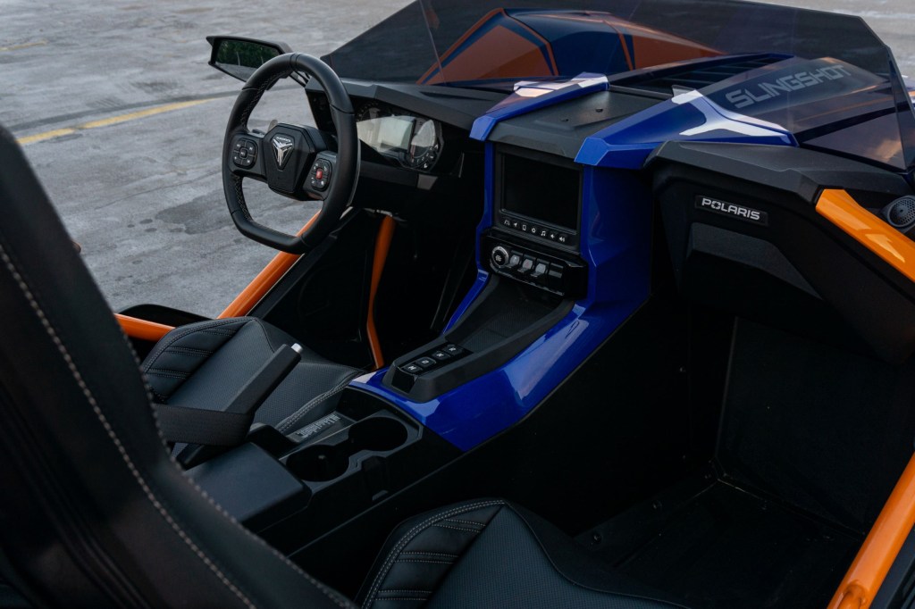 The black cockpit of a blue-and-orange 2021 Polaris Slingshot R