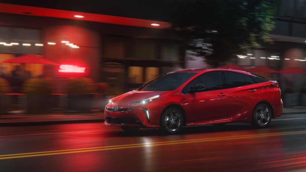 A 2021 Toyota Prius hybrid hatchback driving through a city at night