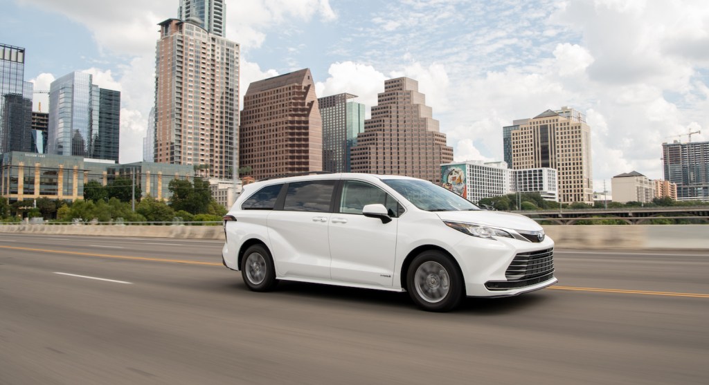 A white 2021 Toyota Sienna driving in the city