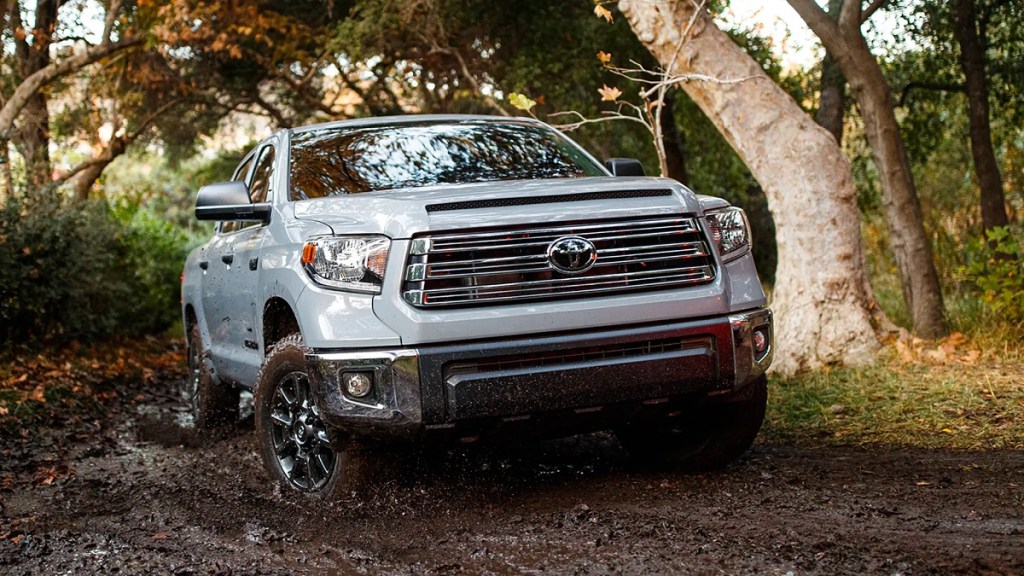 A white 2021 Toyota Tundra pickup truck model driving through the woods.