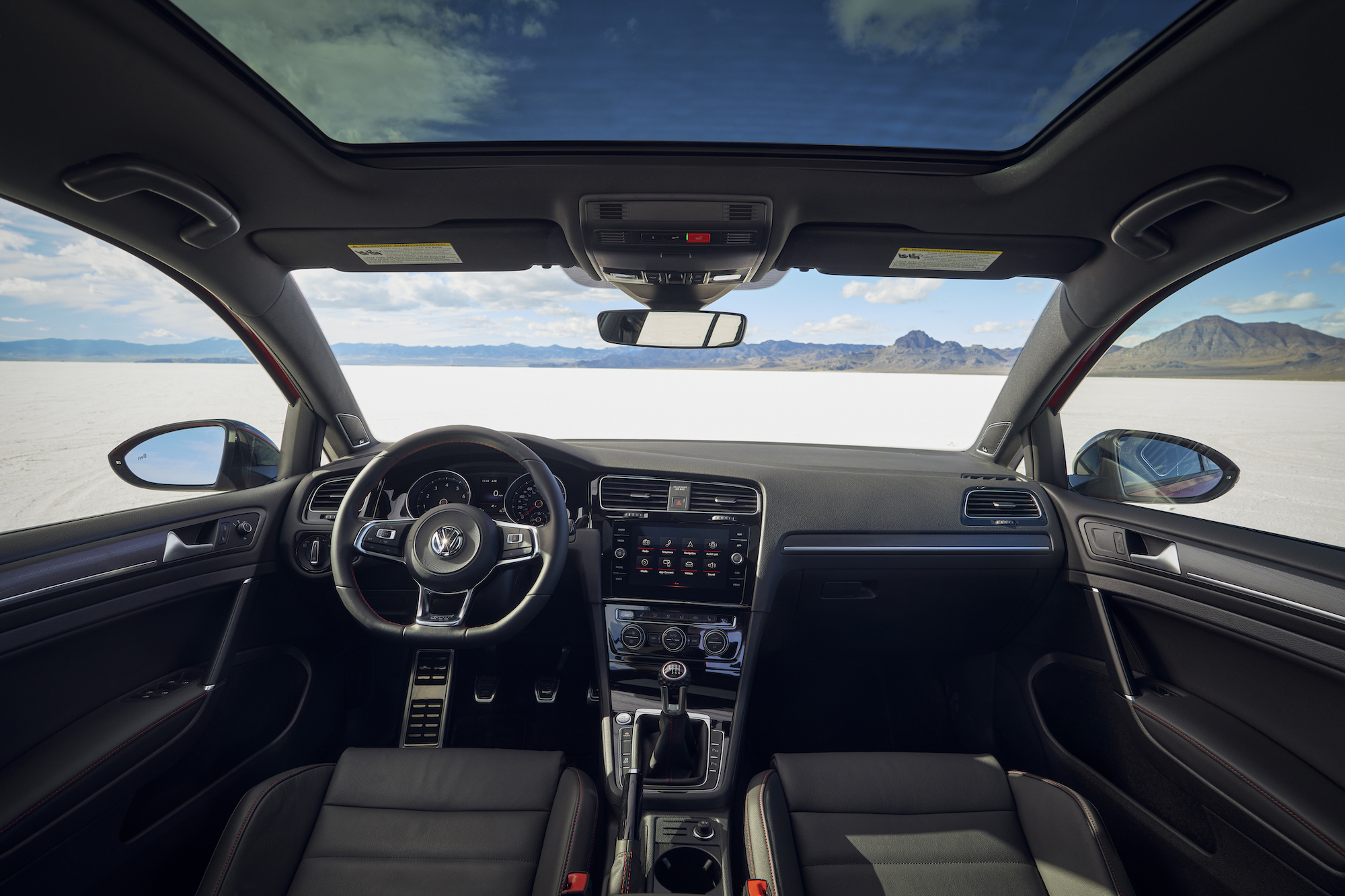 The black interior of a 2021 Volkswagen Golf GTI hatchback parked in a desert