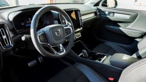Interior view of the front seats, steering wheel, and dashboard of a 2021 Volvo XC40 Recharge electric compact SUV