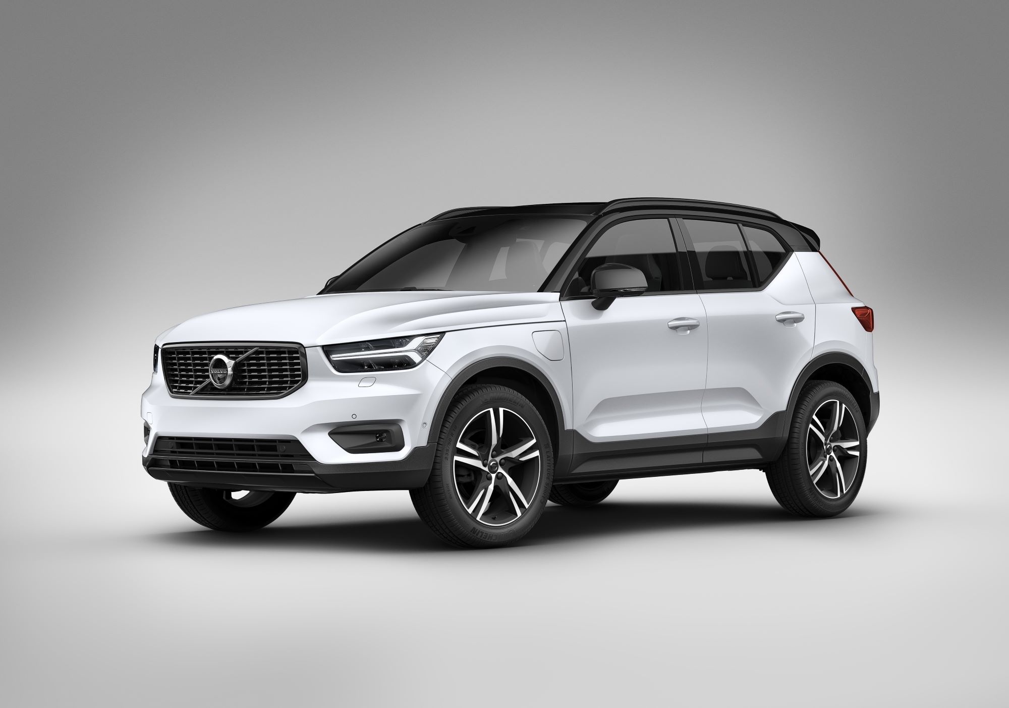A white 2021 Volvo XC40 in front of a cream background and ground with a black vignette on the outside edges.