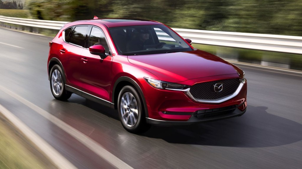 A red 2021 Mazda CX-5 driving through the city