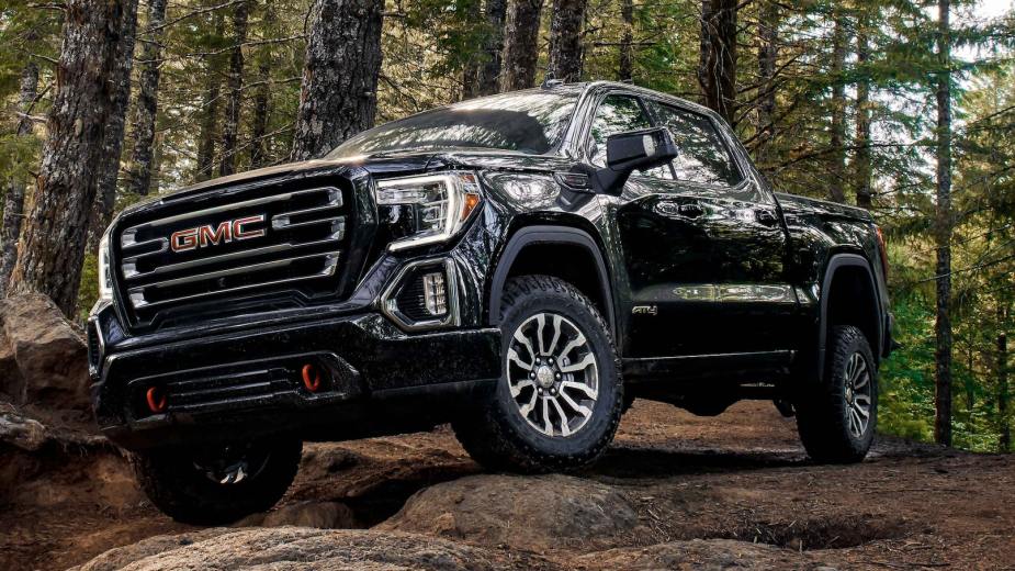 A black 2021 GMC Sierra AT4 off-roading in the woods