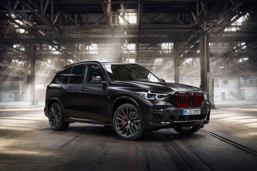 A 2022 BMW X5 Black Vermilion Edition luxury SUV parked in a sun-dappled warehouse