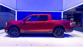 The side view of a red 2022 Ford Maverick Lariat with a bike in the bed at the 2021 Chicago Auto Show