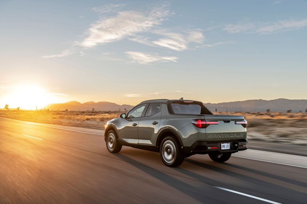 The 2022 Hyundai Santa Cruz pickup truck driving down a country highway as the sun rises