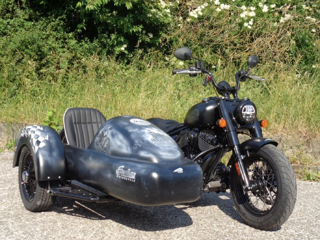 A black 2022 Indian Chief Bobber with Iwan Bikes' BellaVista sidecar parked by the side of the road