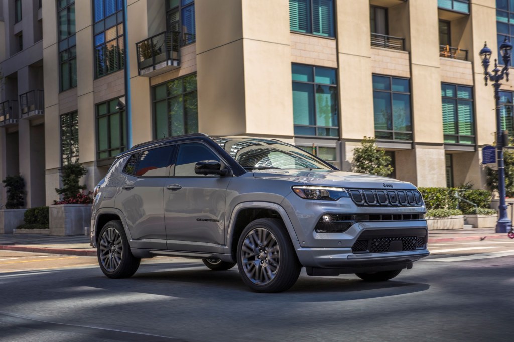 A silver 2022 Jeep Compass with High Altitude Package drives through a city