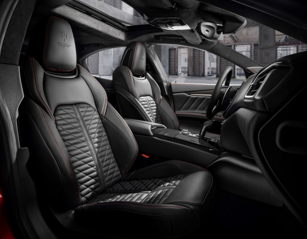 The red-stitched black-leather front sport seats and carbon-fiber-trimmed center console of the 2022 Maserati Ghibli Trofeo sedan