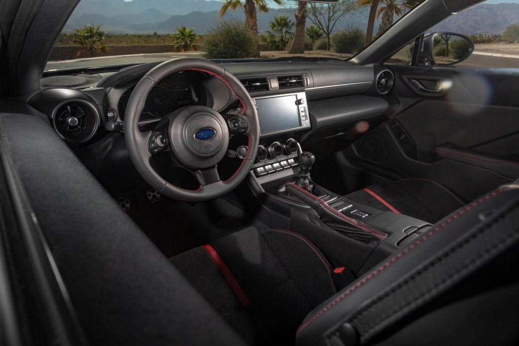 The black-and-red front seats and dashboard of a manual 2022 Subaru BRZ