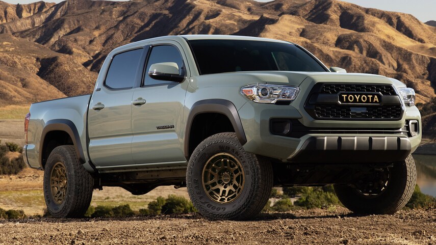 a 2022 Toyota Tacoma pickup truck parked in the dirt near mountains