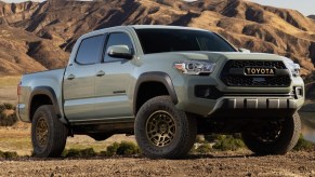 a 2022 Toyota Tacoma pickup truck parked in the dirt near mountains