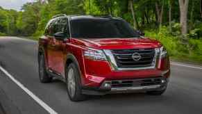 A red 2022 Nissan Pathfinder driving down the road